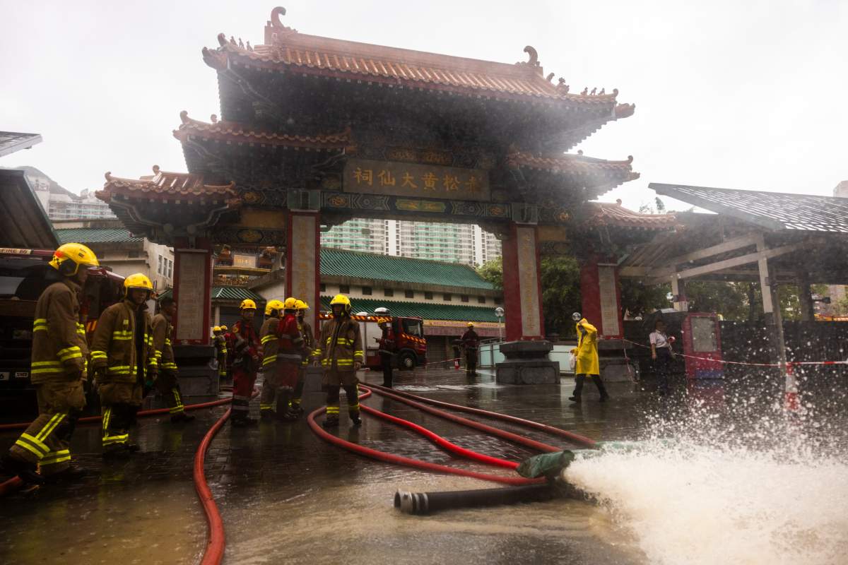 Firefighters drain out water following heavy rainstorms in Hong Kong, Friday, Sept. 8, 2023. (AP Photo/Louise Delmotte)