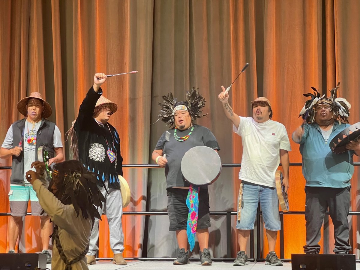 A group of people stand with drums