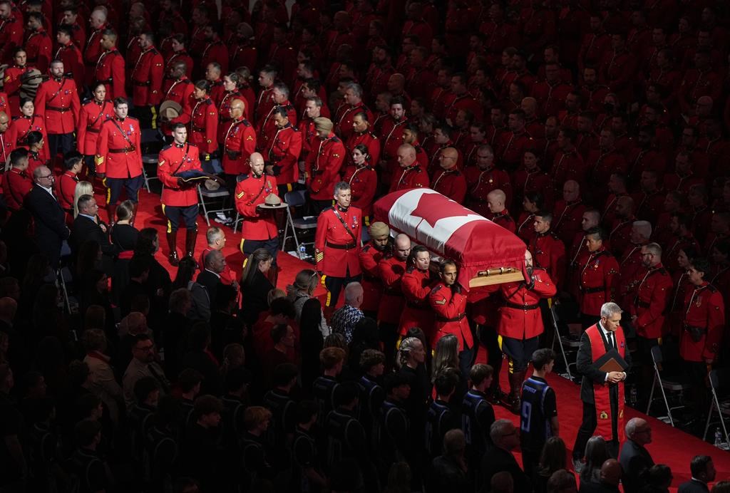 Pallbearers carry RCMP Const. Rick O'Brien's casket into a regimental funeral in Langley, B.C., on October 4, 2023.