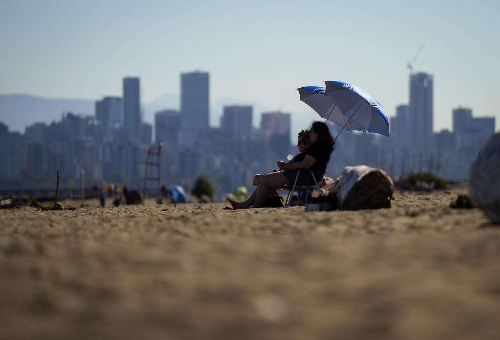People sit under umbrellas on the beach