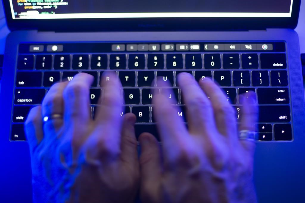 A man uses a computer keyboard in Toronto. A four-day, province-wide investigation into internet child exploitation called 'Project Limestone' resulted in the arrest of 10 individuals.