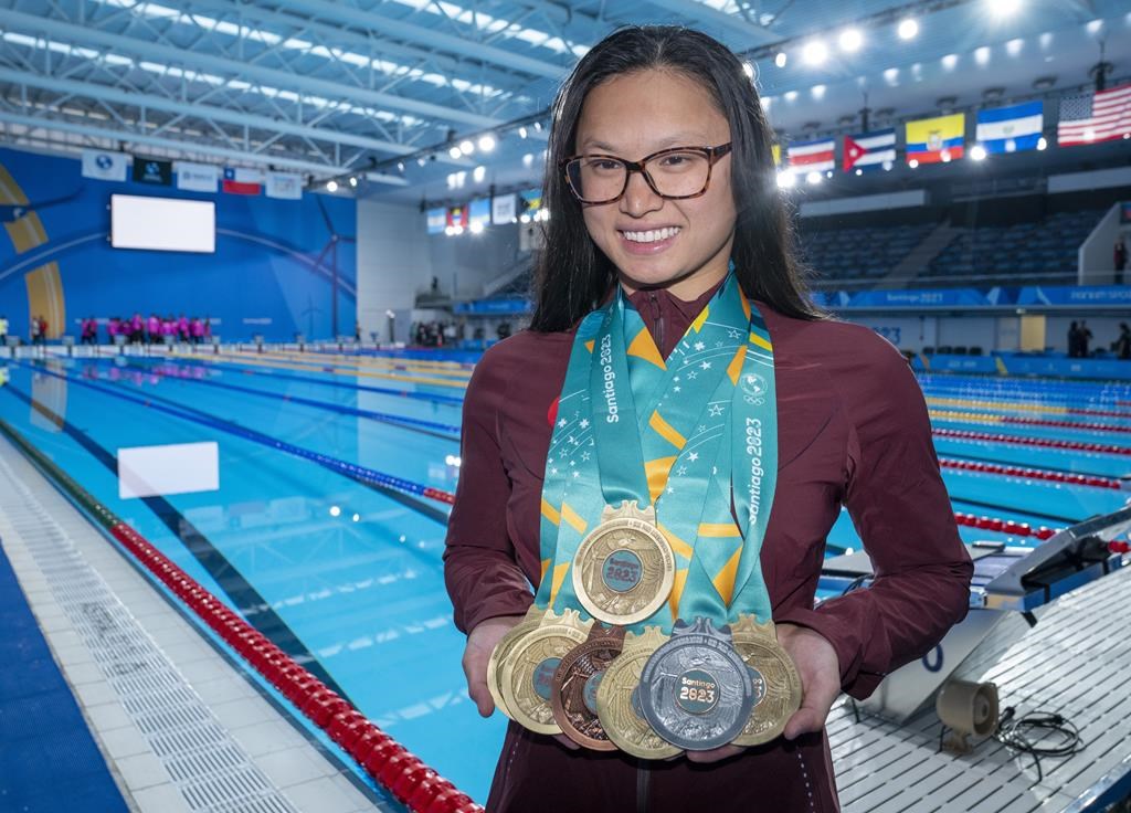 Team Canada's Maggie Mac Neil shows off her medal haul at the conclusion of the swimming competition at the Pan American Games in Santiago, Chile on Wednesday. THE CANADIAN PRESS/Frank Gunn.