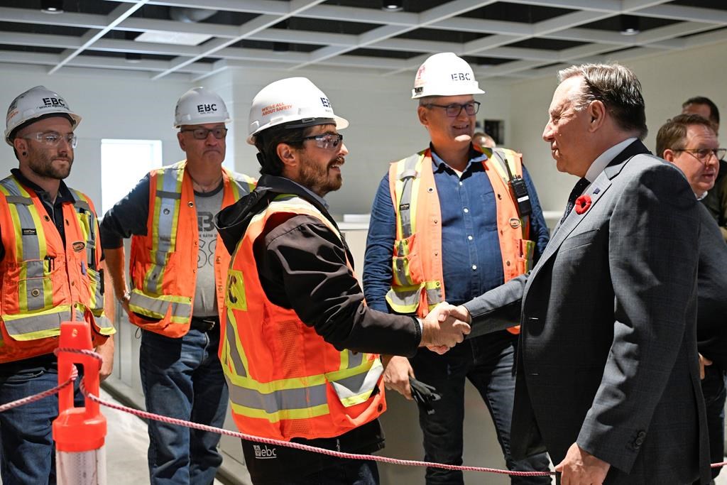 Quebec Premier François Legault hopes to train anywhere from 4,000 to 5,000 new construction workers in certain trades to deal with a labour shortage in the province's construction industry. Legault meets construction workers inside a school under construction during an announcement in Quebec City, Monday, Oct. 30, 2023. 