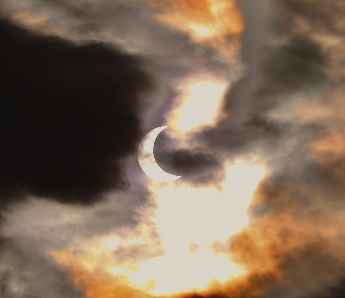 A photo of the partial annular eclipse, with clouds partially obscuring it, seen from Vernon, B.C., on Saturday, Oct. 14, 2023.