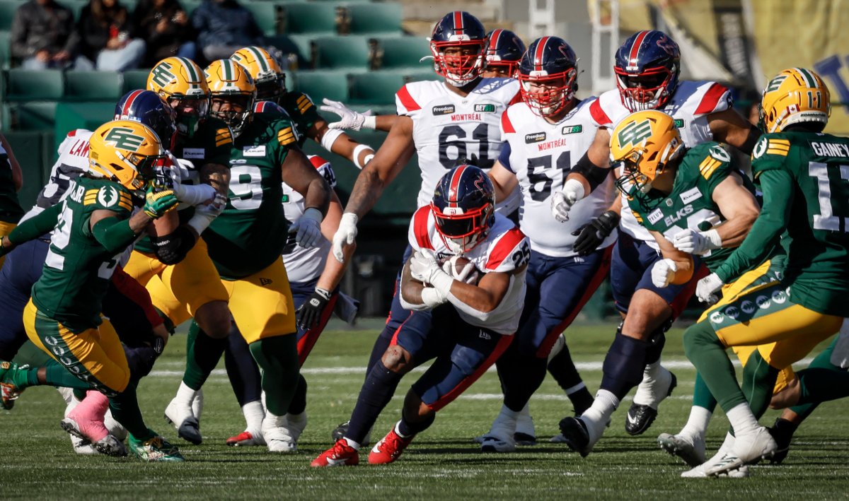 Montreal Alouettes running back Walter Fletcher, centre, runs the ball past Edmonton Elks players during first half CFL football action in Edmonton, Saturday, Oct. 14, 2023.