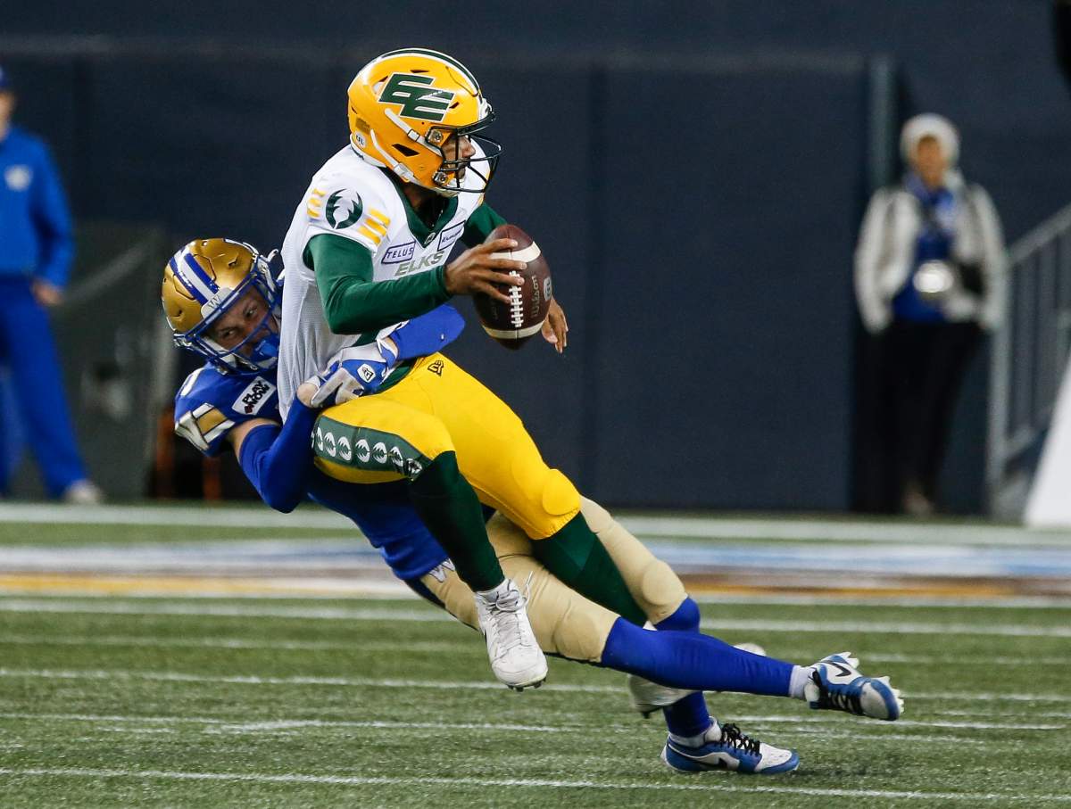 Winnipeg Blue Bombers' Evan Holm (31) sacks Edmonton Elks quarterback Tre Ford (2) during second half CFL action in Winnipeg, Saturday, Oct. 21, 2023.