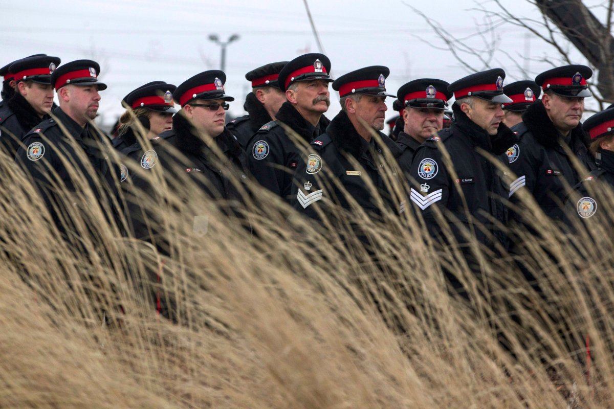 Toronto police officers march to the memorial service for Const. John Zivcic in Toronto on Monday, Dec. 9 2013. A spokesperson for TPS says the dangers of the job may be discouraging some potential applicants.