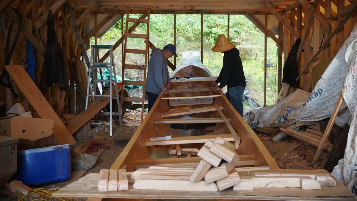 Mike Robinson (left) and Tom Cordeiro work on what is believed to be the Haisla Nation's first oceangoing canoe built in three decades from Robinson's shed in Kitimaat Village on Sun. Oct. 1, 2023.