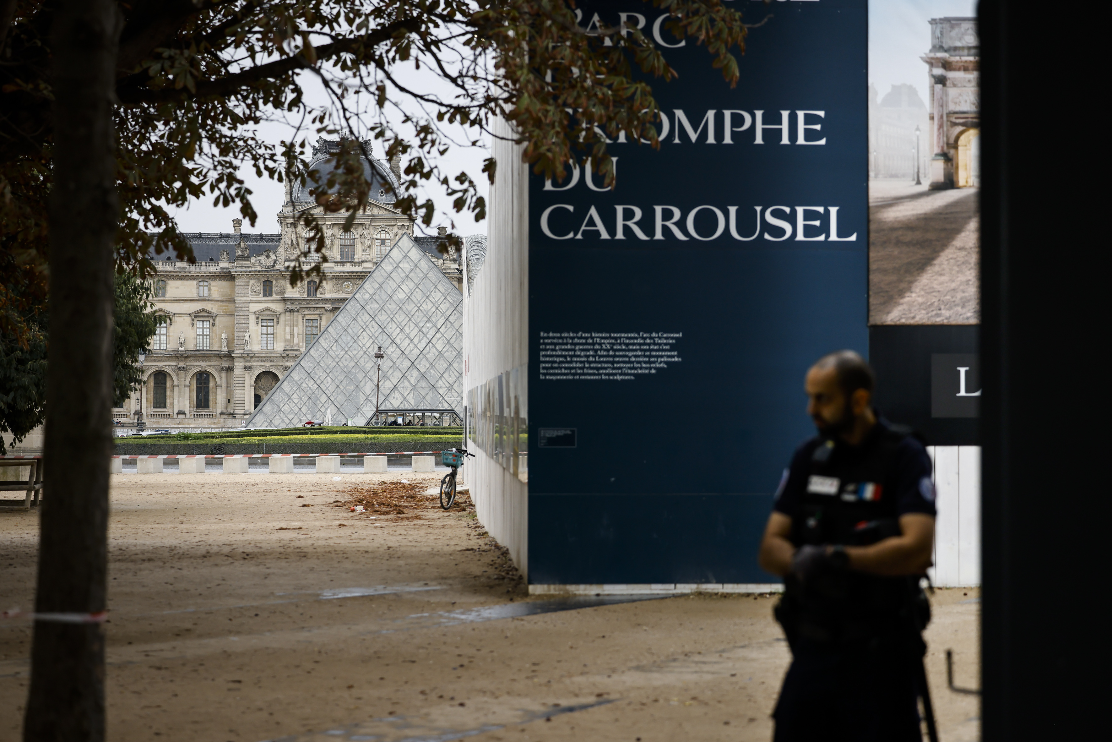 A police officer stand guard outside the Louvre Museum
