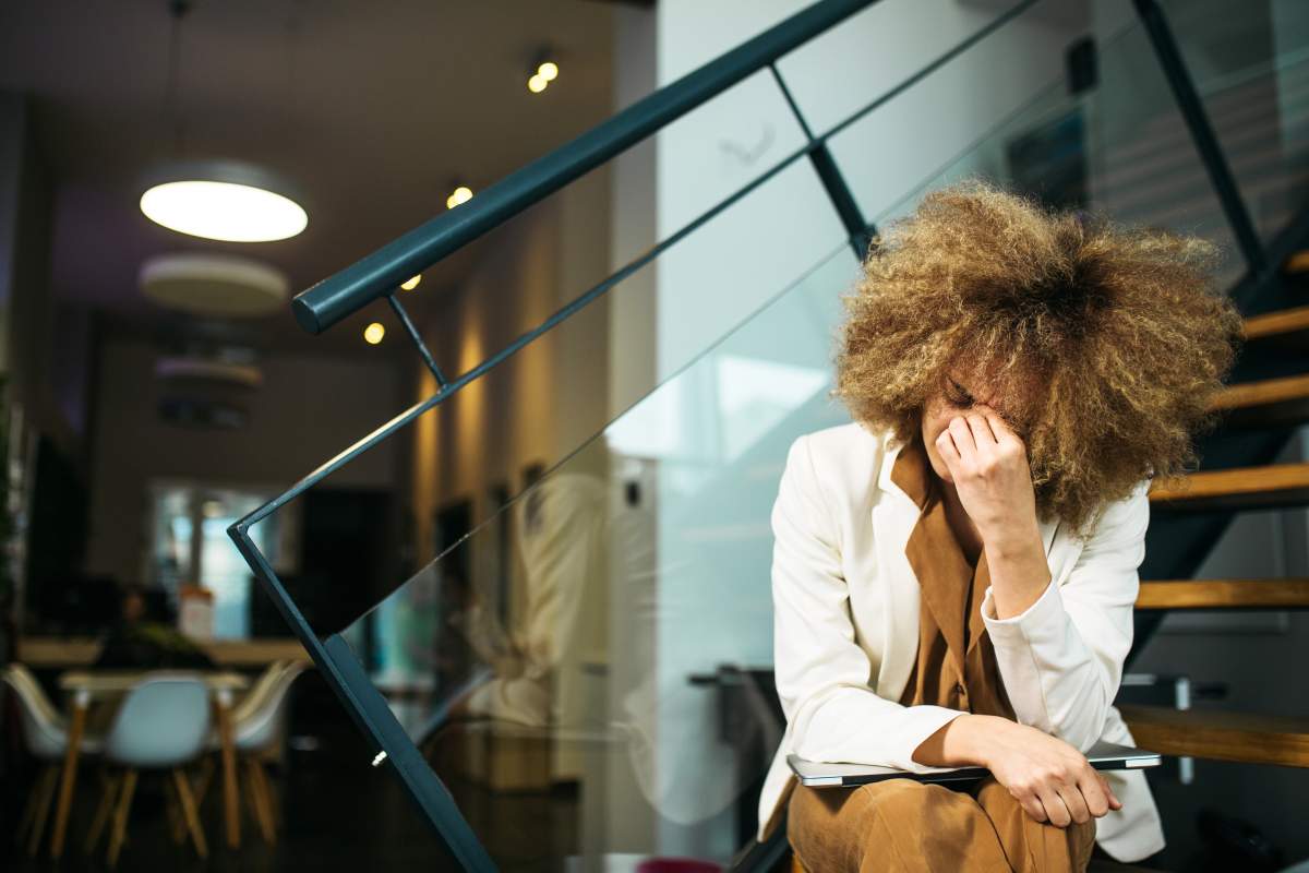 Beautiful businesswoman using laptop while sitting on the steps in a modern office