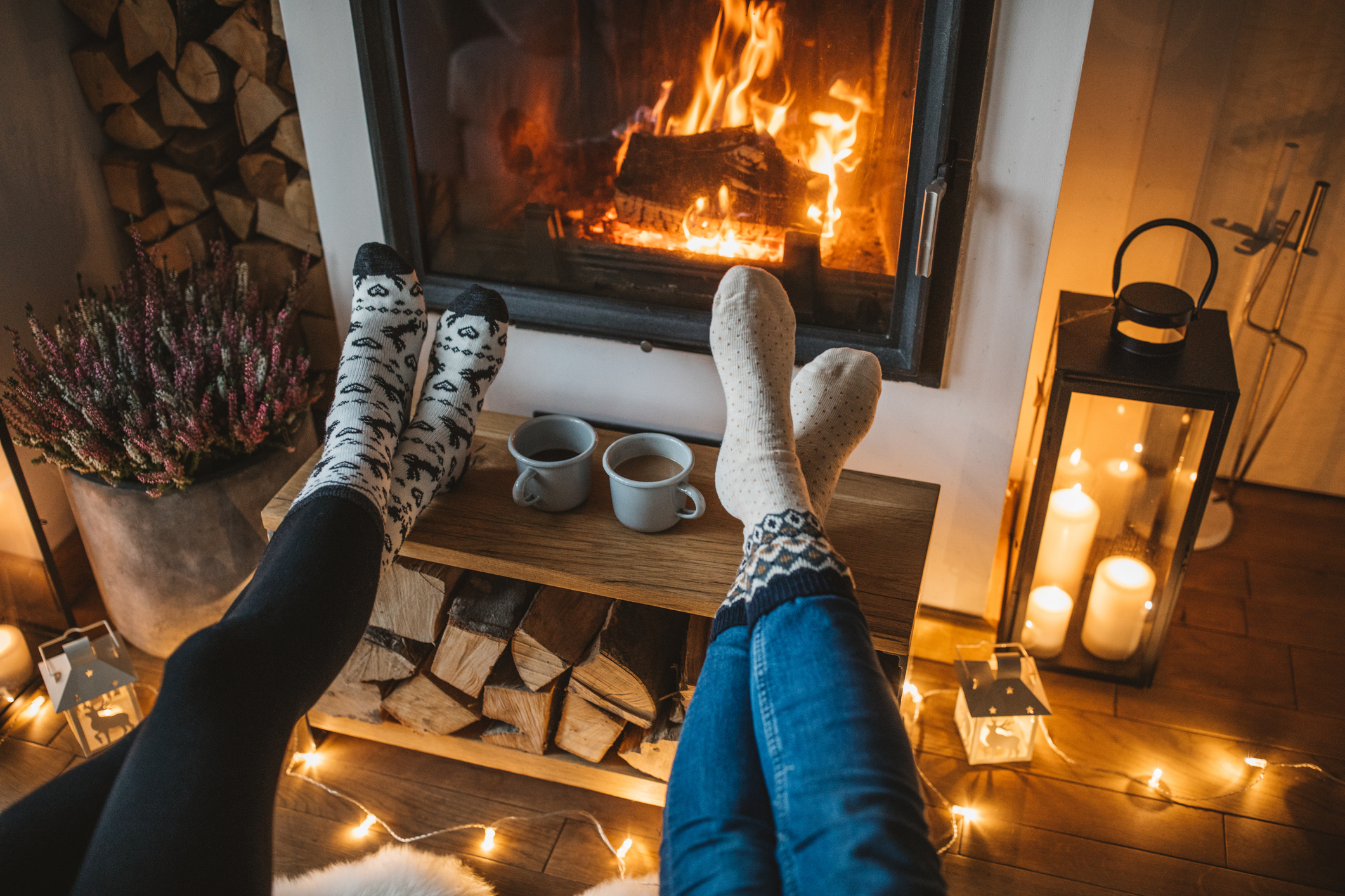 two people sitting in front of a fireplace