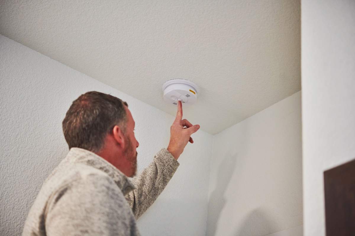 Man checks smoke detector