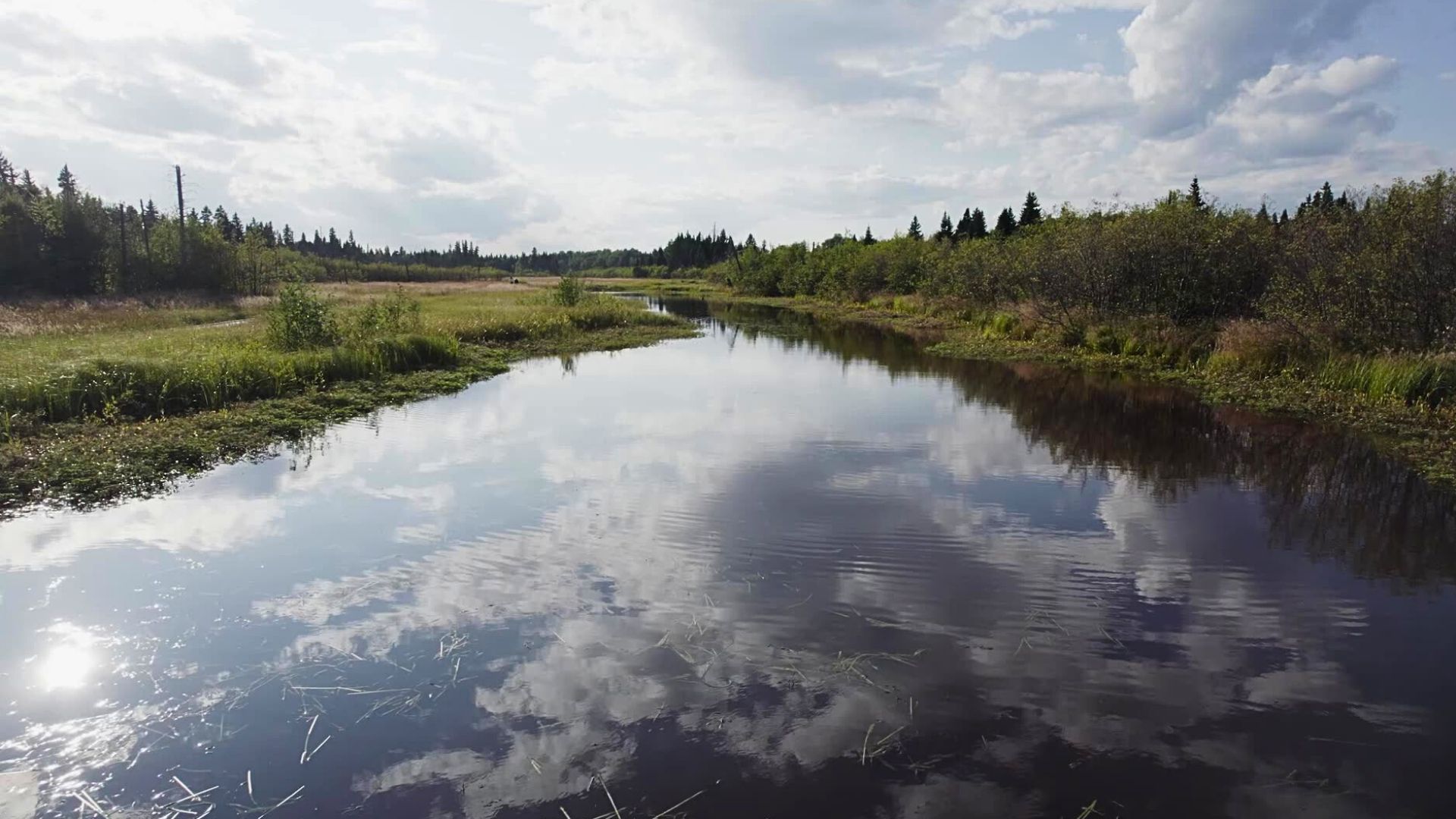 Clouds reflect in a river off the Birch Island Boardwalk Trail in Happy Valley-Goose Bay, Labrador.