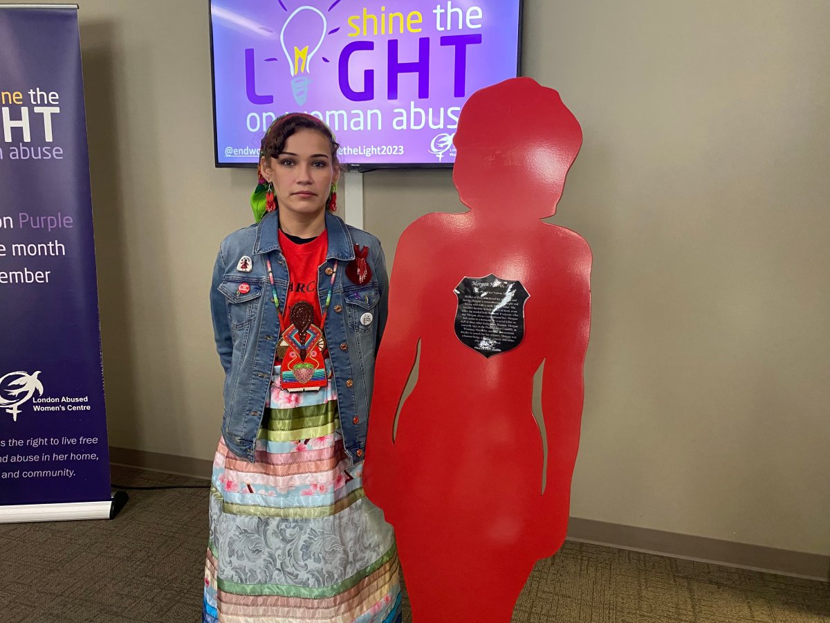 Cambria Harris, daughter of homicide victim Morgan Harris, stands next to the silent witness silhouette at the London Abused Women's Centre (LAWC) created in honour of her mother for the 14th annual Shine the Light campaign.