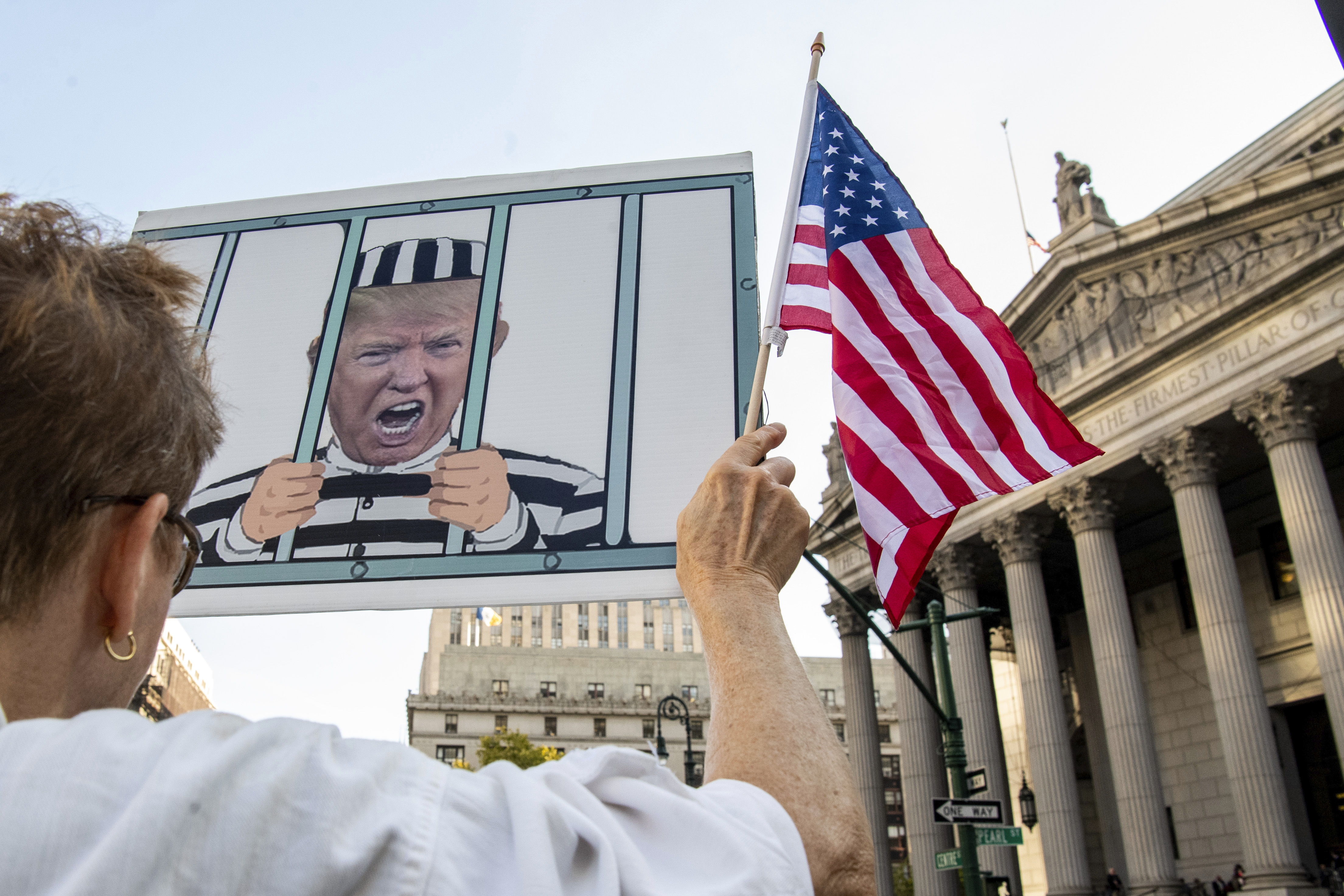 Protesters chant outside New York Supreme Court ahead of former President Donald Trump's civil business fraud trial on Monday