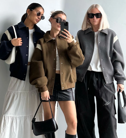 Three girls wearing bomber jackets