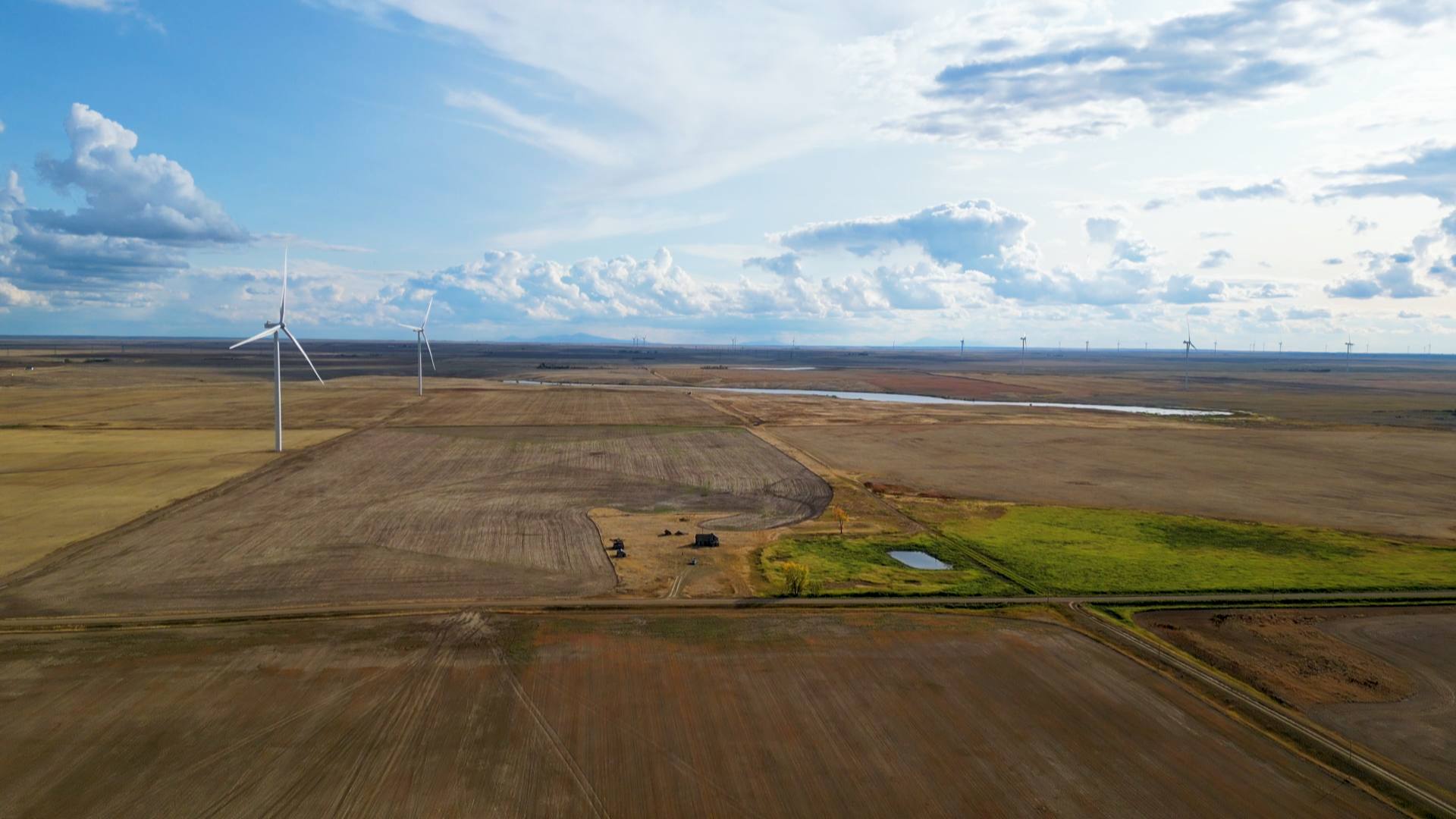 Wind turbines can be seen at a distance in Southern Alberta, one of the windiest regions in Canada.