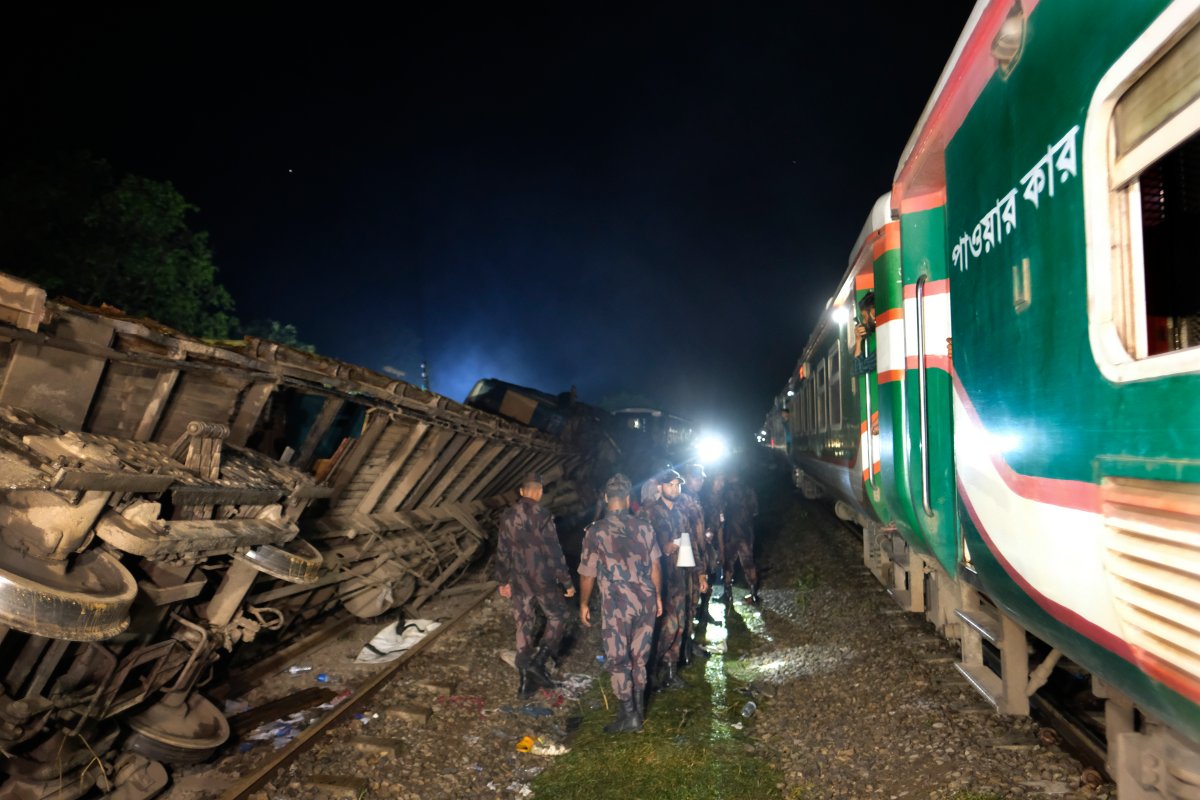 Policemen stand guard at the site of an accident where a cargo train has hit a passenger train at Bhairab, Kishoreganj district, Bangladesh, Monday, Oct. 23, 2023, leaving more than dozen people dead and scores injured. 