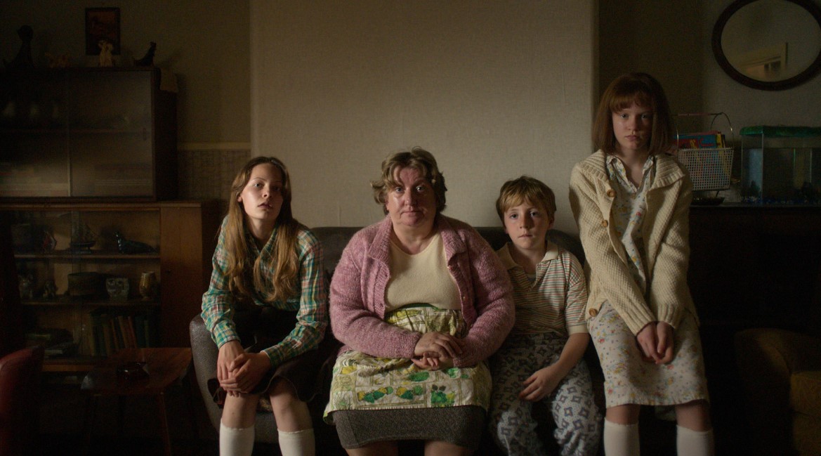 Charlotte Miller as Margaret Hodgson, Paula Benson as Peggy Hodgson, Daniel Lee as Billy Hodgson and Olivia Booth-Ford as Janet Hodgson in The Enfield Poltergeist, premiering October 27, 2023 on Apple TV+.