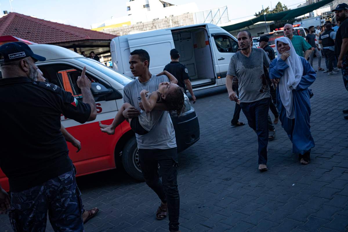 A Palestinian man carries a wounded girl into Shifa hospital in Gaza City, Tuesday, Oct. 10, 2023. The militant Hamas rulers of the Gaza Strip carried out an unprecedented attack on Israel Saturday, killing over 900 people and taking captives. Israel launched heavy retaliatory airstrikes on the enclave, killing hundreds of Palestinians.