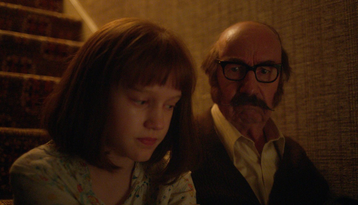 Olivia Booth-Ford as Janet Hodgson and Christopher Ettridge as Maurice Grosse in 'The Enfield Poltergeist,' premiering October 27, 2023 on Apple TV+.