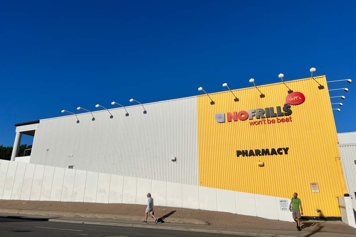A person exits the pedistrian ramp in front of an ominous-looking No Frills grocery store in Toronto, on Aug 11, 2022.