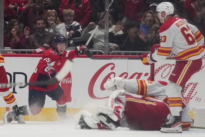 Washington Capitals centre Matthew Phillips celebrates his goal past Calgary Flames goaltender Jacob Markstrom in the second period of an NHL hockey game, Monday, Oct. 16, 2023, in Washington.