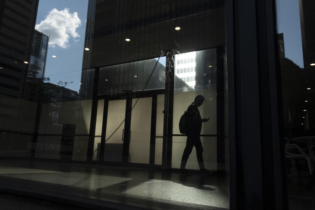 Ontario is considering banning the use of non-disclosure agreements in cases of workplace sexual harassment, misconduct or violence. A person walks though a downtown Toronto office building with other buildings reflected in a window in this June 11, 2019 photo. 