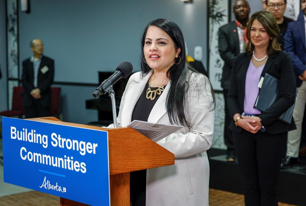 Minister Rajan Sawhney speaks at an announcement as Alberta Premier Danielle Smith looks on in Calgary, Alta., Friday, April 14, 2023. The Alberta government is proposing changes to a tech job title to help make it easier for tech firms to recruit workers.