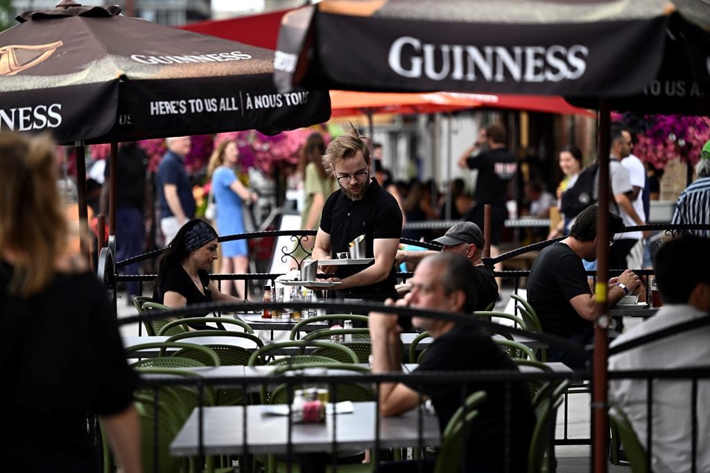 Ontario is planning to explicitly ban unpaid trial shifts for restaurant and hospitality workers, while also strengthening rules against deducting employee wages in the event of customer theft. A server works on the patio of a pub in the ByWard Market in Ottawa, on Friday, June 23, 2023. THE CANADIAN PRESS/Justin Tang.