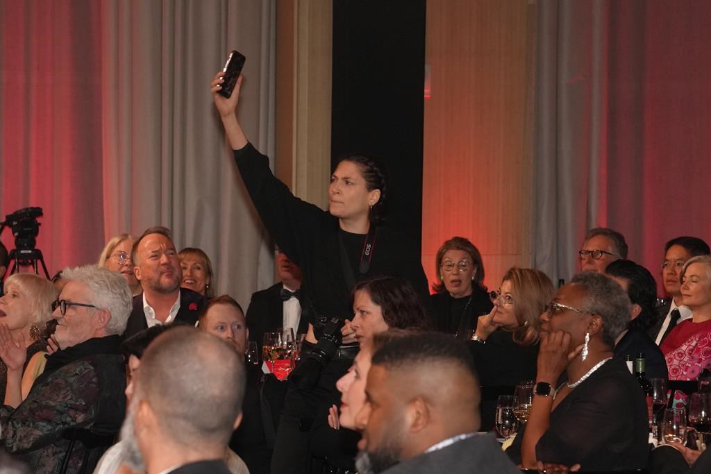 A protester films herself as she interrupts the Scotiabank Giller Prize in Toronto, on Monday, November 13, 2023. 