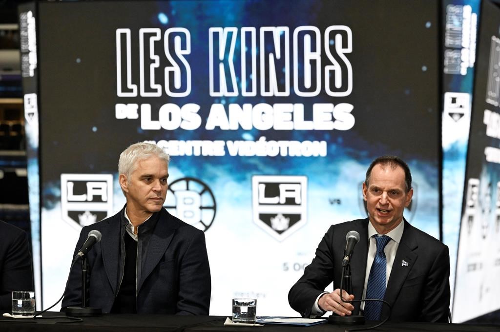 Quebec Finance Minister Eric Girard speaks at a news conference, Tuesday, Nov. 14, 2023 at the Videotron Centre in Quebec City as Luc Robitaille, president of the Los Angeles Kings, left, looks on. Quebec Premier François Legault is defending his government’s decision to spend up to $7 million to bring the Kings to Quebec City for two NHL pre-season games next year.
