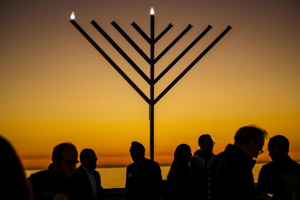 FILE - People gather around the 10-foot menorah during the "Hanukkah on the Pier" event at the end of the San Clemente pier hosted by Chabad of San Clemente in San Clemente, Calif., Sunday, Dec. 18, 2022. (Leonard Ortiz/The Orange County Register via AP, File)