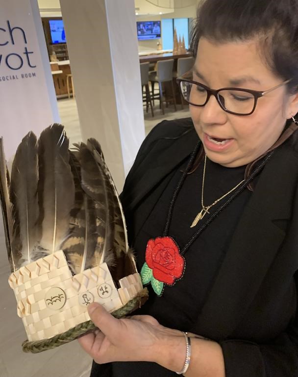 Andrea Paul, the regional chief of the Assembly of First Nations in Nova Scotia, explains the Mi'kmaq hieroglyphics on the headdress made for her induction into her new position in Dartmouth, N.S. on Thursday, Nov. 30, 2023. Paul is the first woman to hold the position in Nova Scotia. THE CANADIAN PRESS/Michael Tutton.