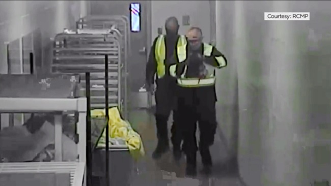 Two men dressed as contractors appear in a still image from security video helping to free Alkhalil from North Fraser Pretrial Centre