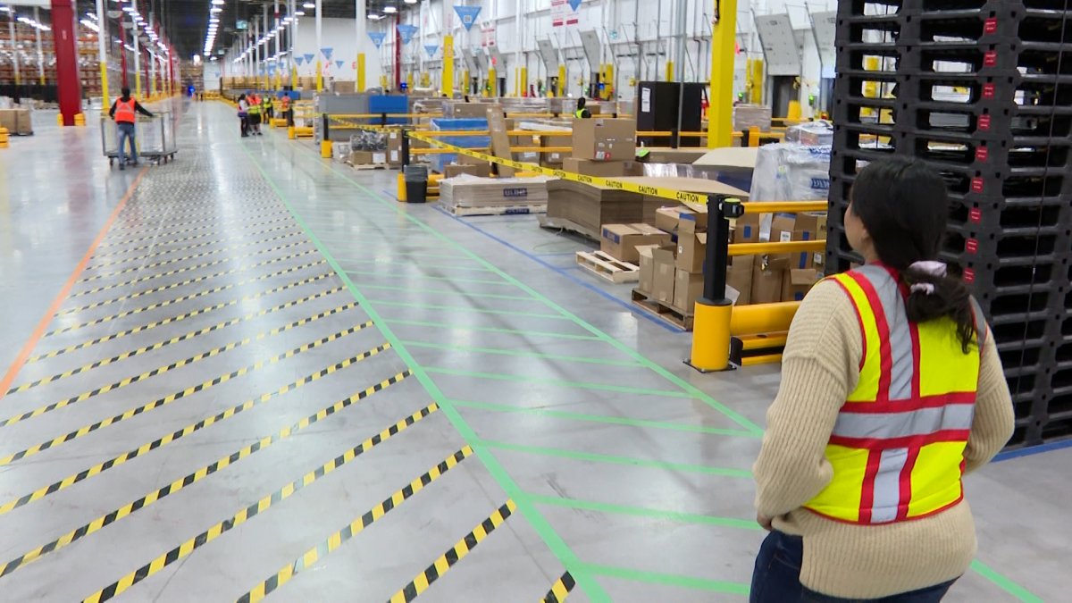 Site Lead, Aman Chouhan leads a tour of Amazon's YGK-1 fulfillment centre in Belleville, Ont.  