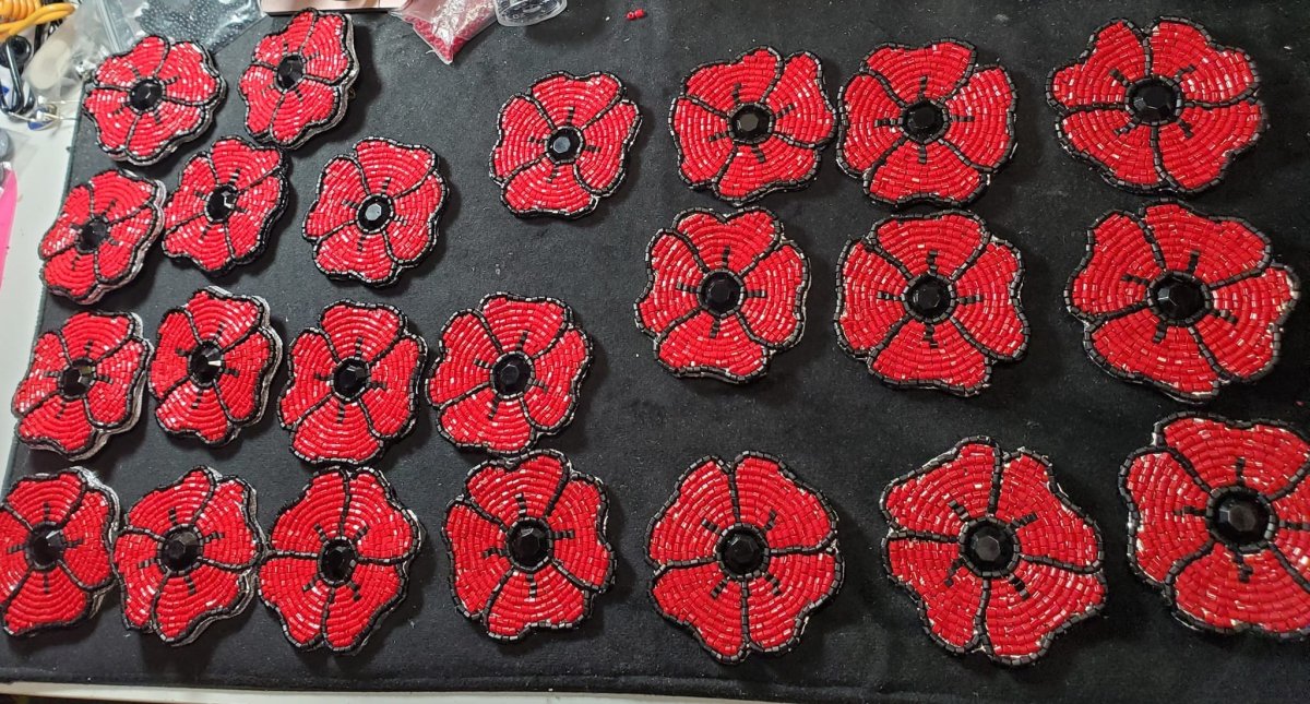 A bunch of beaded poppies pictured on a black backing