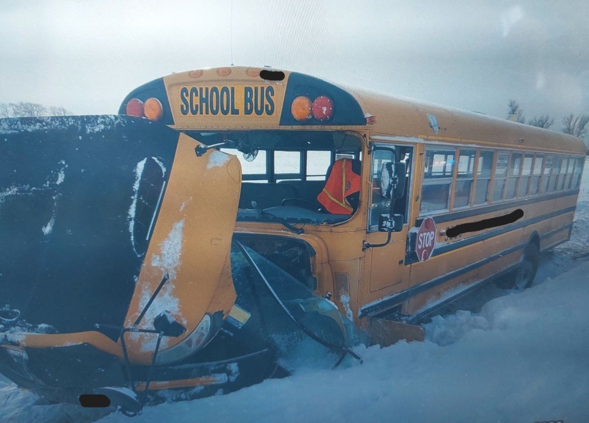 The front of a school bus on a snowy road smashed in following a crash.