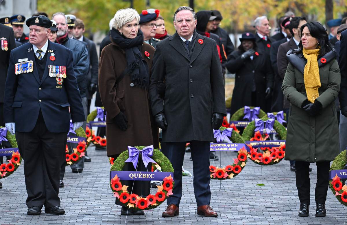 Quebec Premier Francois Legault, centre, alongside his wife Isabelle Brais and Montreal Mayor Valerie Plante, right, attend a Remembrance Day ceremony in Montreal, Saturday, November 11, 2023.