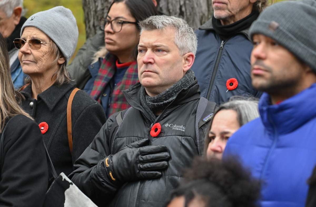 People look on during a Remembrance Day ceremony in Montreal, Saturday, November 11, 2023.