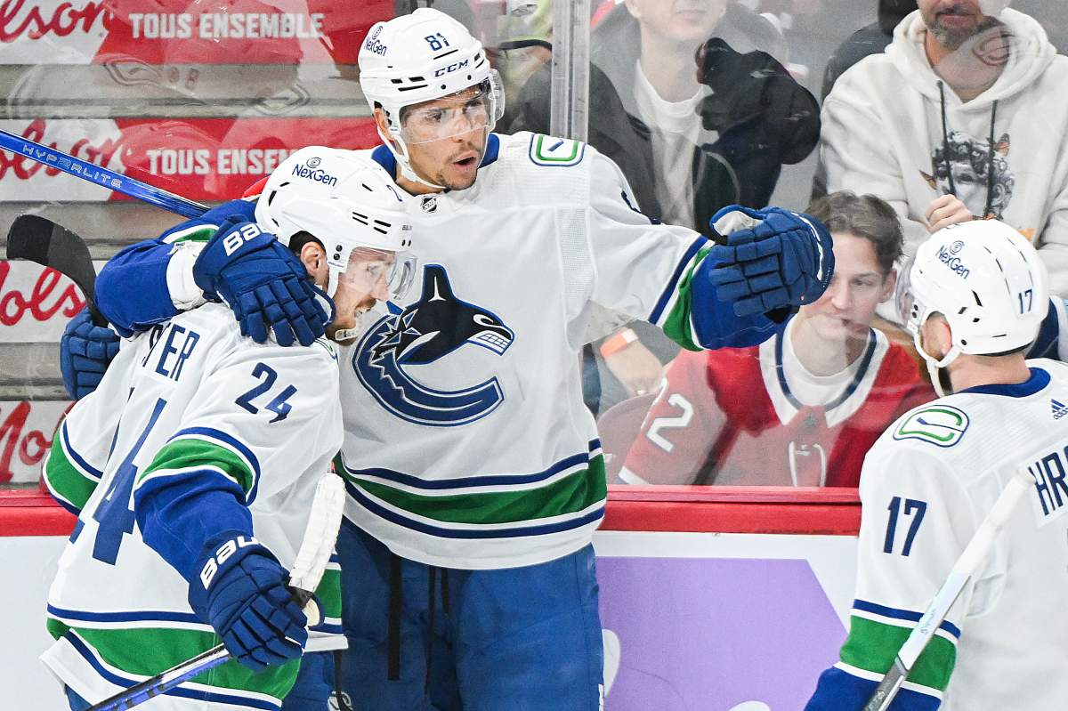Vancouver Canucks’ Dakota Joshua (81) celebrates with teammates Pius Suter (24) and Filip Hronek after scoring against the Montreal Canadiens during the game in Montreal on Nov. 12, 2023.