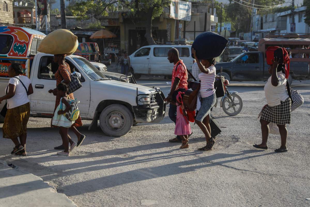 People, who were displaced from their homes due to clashes between armed gangs in Cite Soleil, walk down a street in the Tabarre neighborhood as they seek refuge in Port-au-Prince, Haiti, on Wednesday.