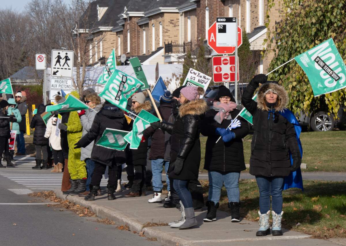 Teachers form a picket line outside their school in Deux-Montagnes, Que., on Tuesday, Nov. 21, 2023.