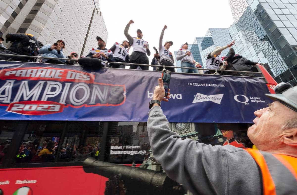 A construction worker cheers on the Montreal Alouettes during the Grey Cup victory parade in Montreal on Wednesday, Nov. 22, 2023.