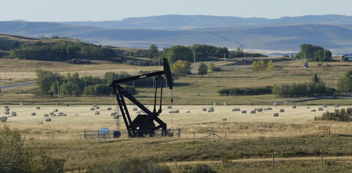 An oilfield pumpjack, belonging to Crescent Point Energy, works producing crude near Longview, Alberta on Sept. 10, 2020. Behind is a harvested hay field.