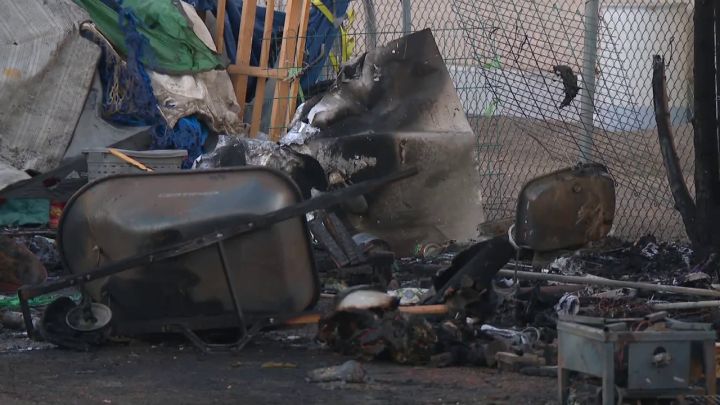 Police officers are looking for a suspect after a woman was found with a stab wound at the scene of a fire at a northeast Edmonton homeless encampment on Friday.