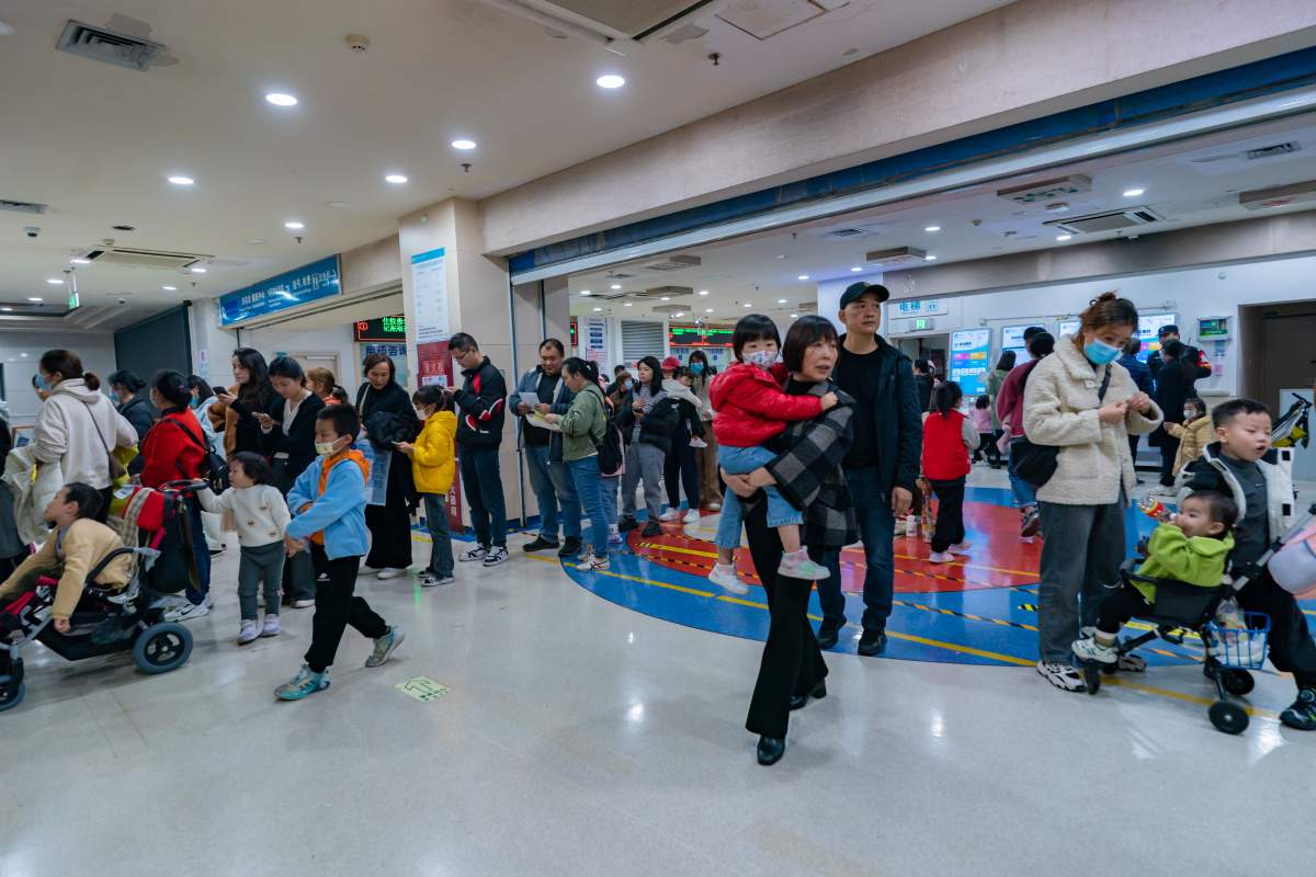 Parents with children suffering from respiratory diseases line up at a children's hospital in Chongqing, China, November 23, 2023.