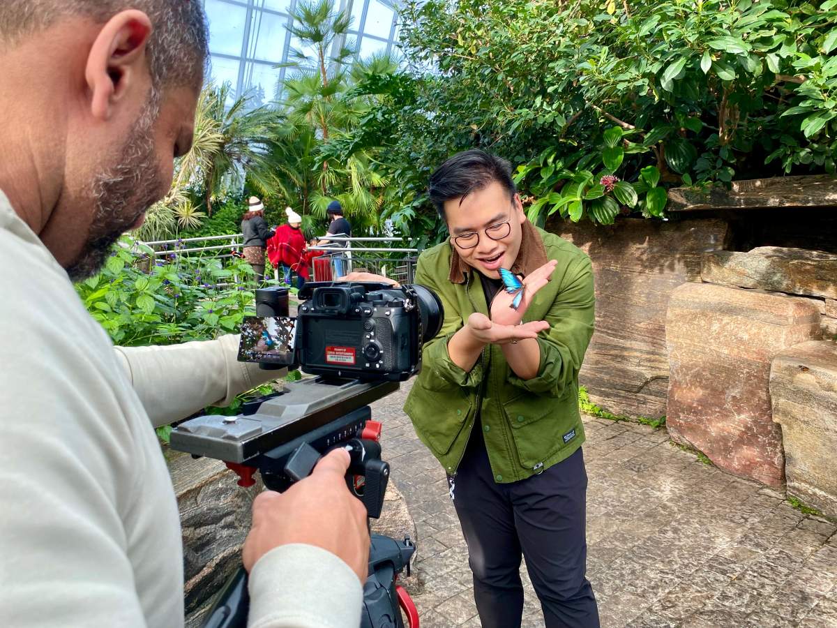 Liem Vu interacting with butterflies at Butterfly Conservatory