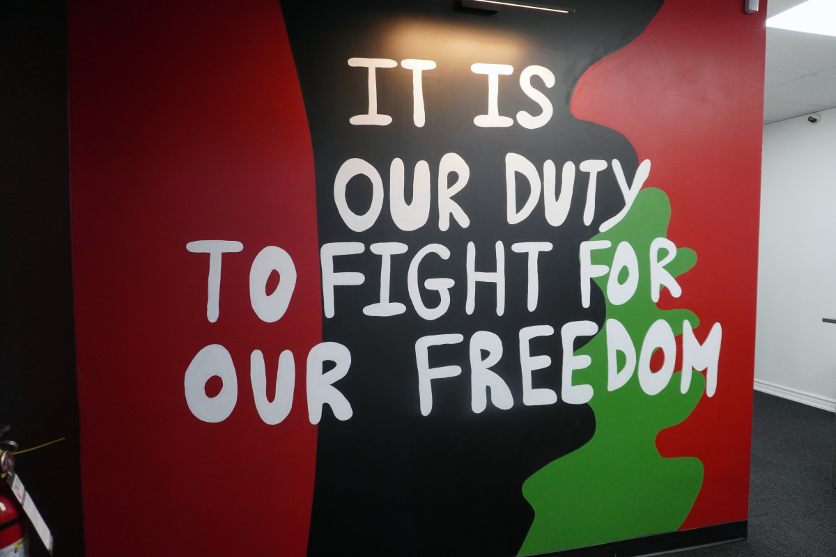 A mural reads "It is out duty to fight for our freedom."