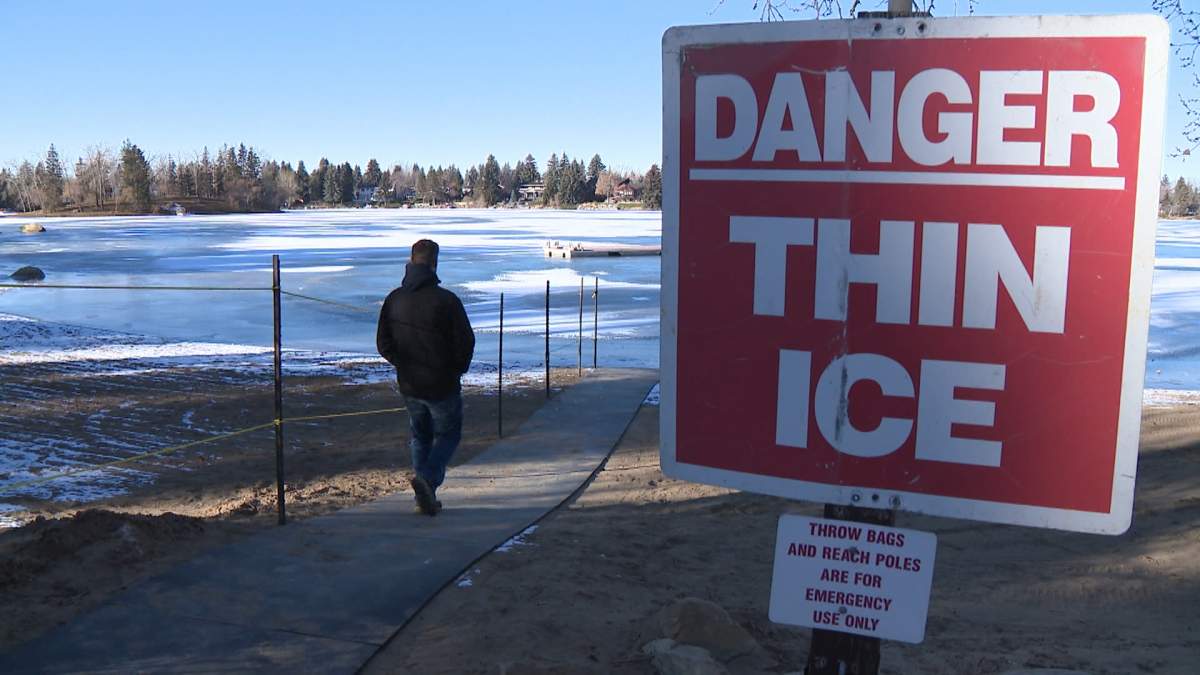 Michael Horder, general manager of Lake Bonavista Community Association, walks next to a ‘Thin Ice’ sign near the lake on Nov. 28.